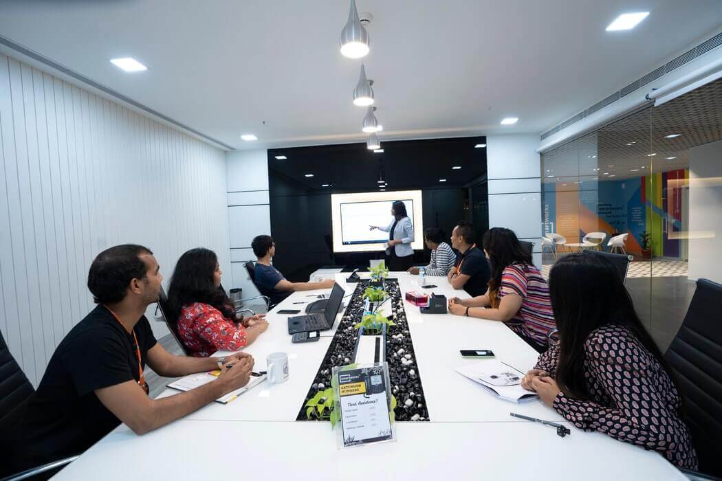 Equipe de trabalho reunida em uma mesa, em treinamento.