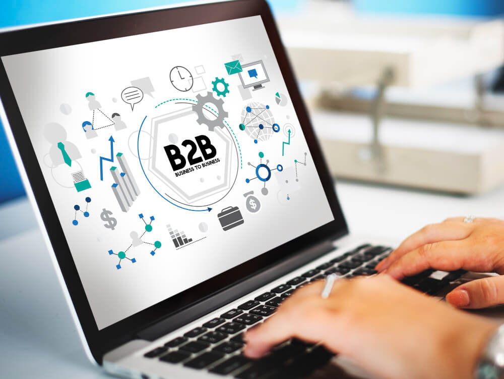Pessoa utilizando notebook com ícones de conexão e tecnologia ao redor da palavra B2B, simbolizando transformação digital e eficiência no atendimento B2B.