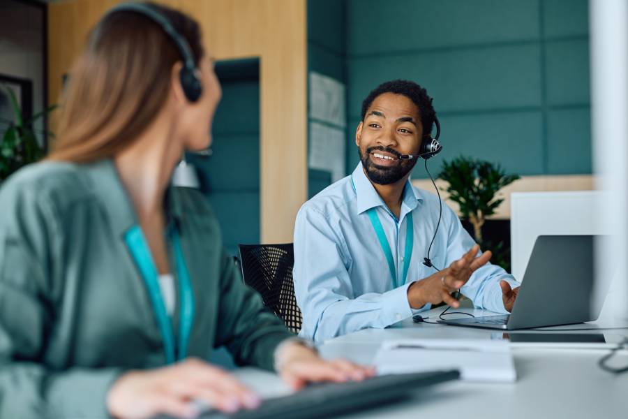 Equipe de atendimento conversando com headsets e notebook, representando atendimento no e-commerce.