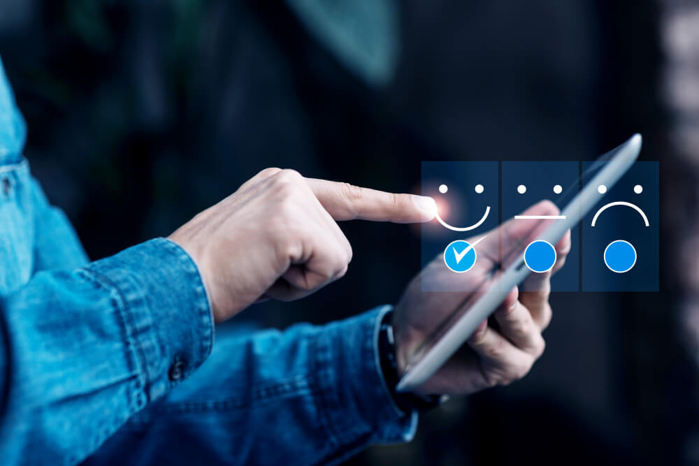 Pessoa avaliando experiência em tablet com ícones de satisfação, representando feedback da experiência do consumidor.