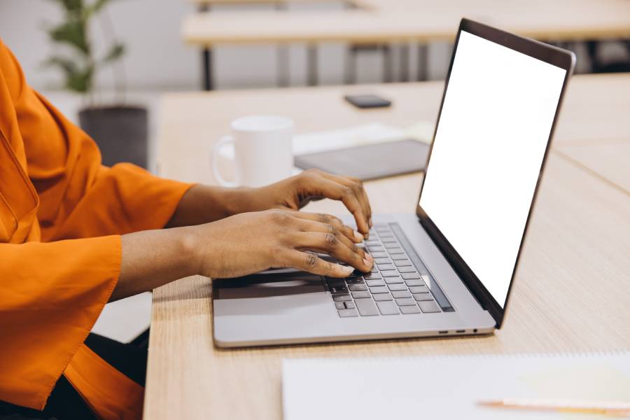 Pessoa digitando no laptop no escritório em rotina de atendimento de "Vendedor Indicado" Shopee 